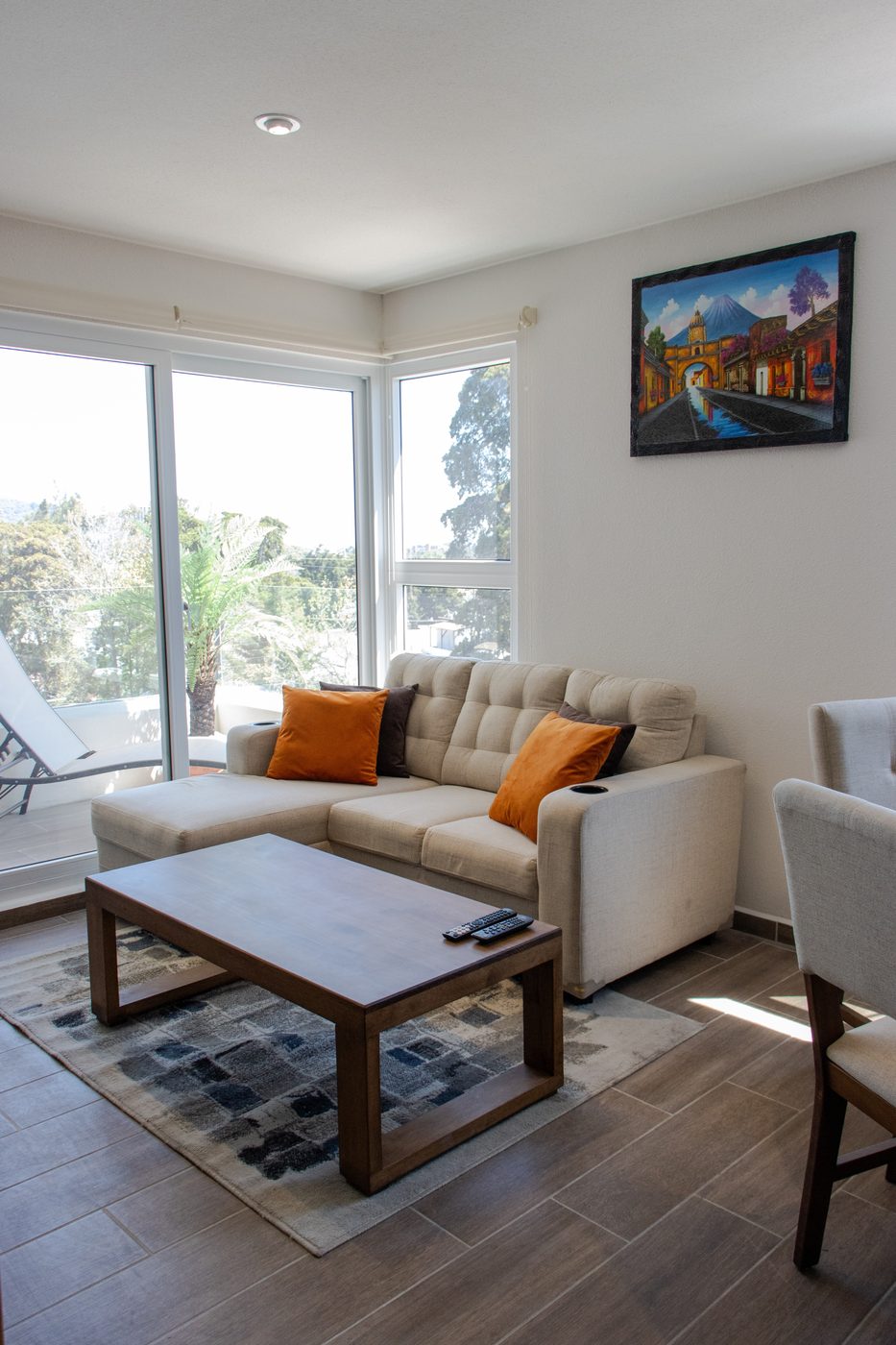 Sala equipada con sillón, mesa de centro y cuadro de Antigua