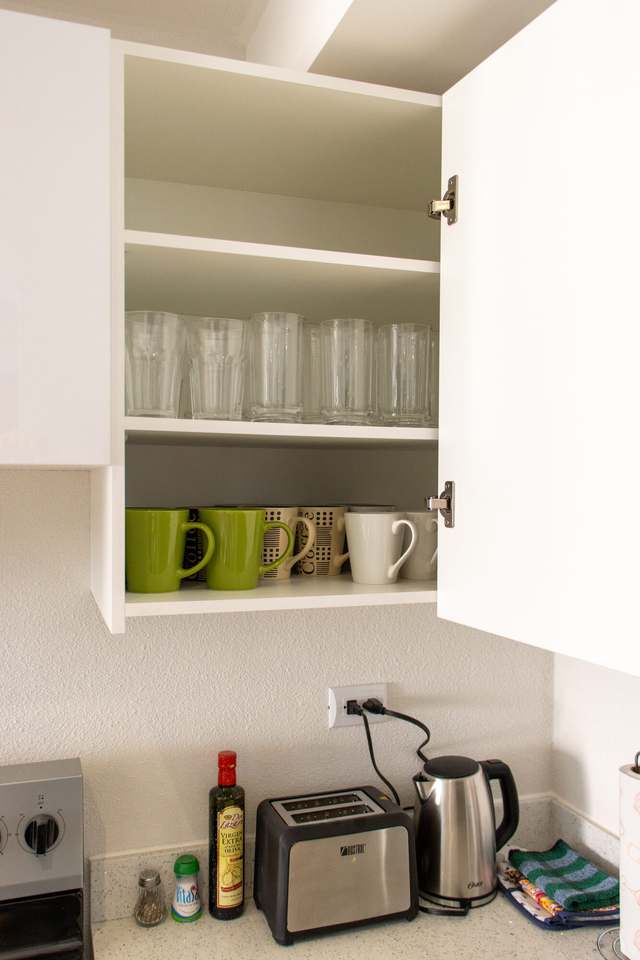 Alacena con vasos y tazas sobre la barra
